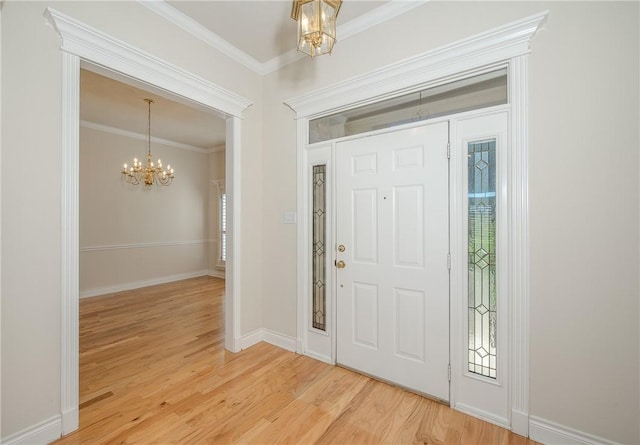 foyer featuring a wealth of natural light, crown molding, an inviting chandelier, and hardwood / wood-style flooring