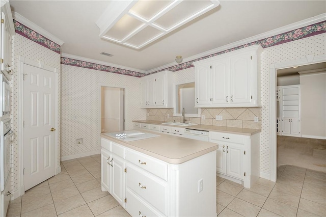 kitchen with a center island, sink, light tile patterned flooring, crown molding, and white cabinets