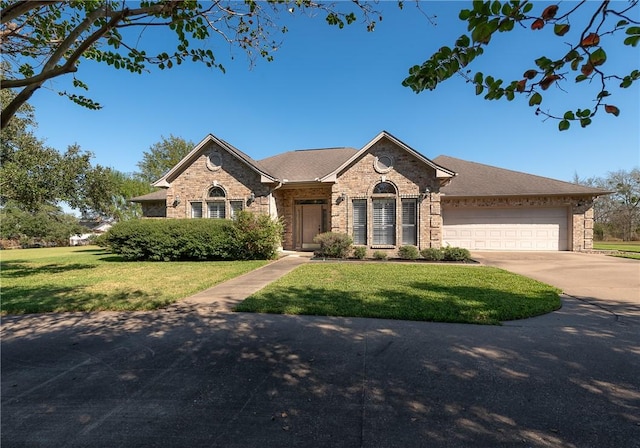 ranch-style home featuring a garage and a front lawn