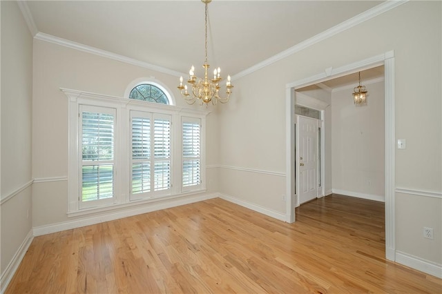 empty room featuring wood-type flooring, ornamental molding, and an inviting chandelier