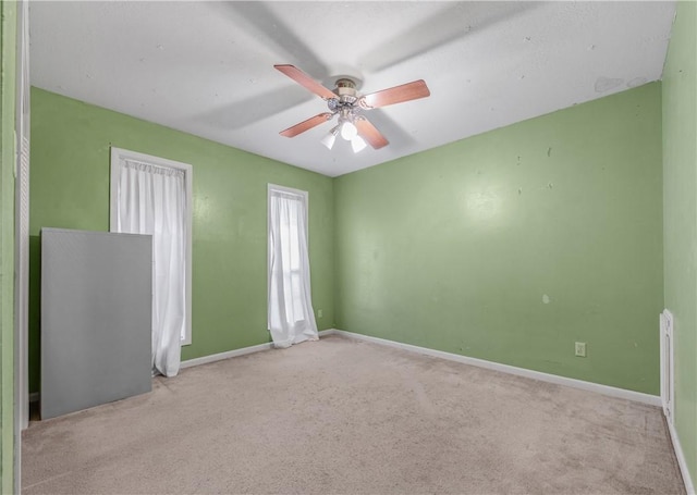 empty room featuring carpet floors, ceiling fan, and baseboards