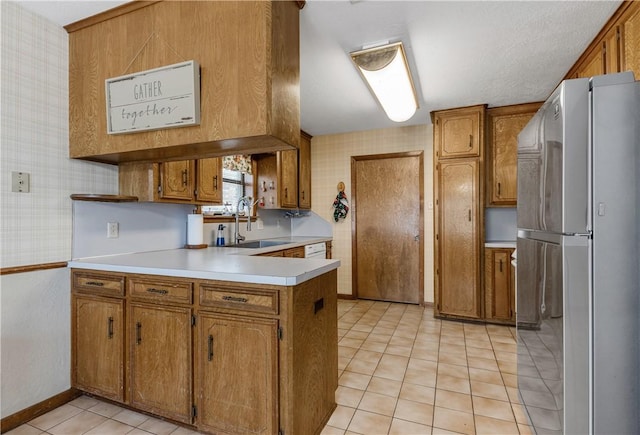 kitchen with sink, stainless steel fridge, kitchen peninsula, and light tile patterned flooring