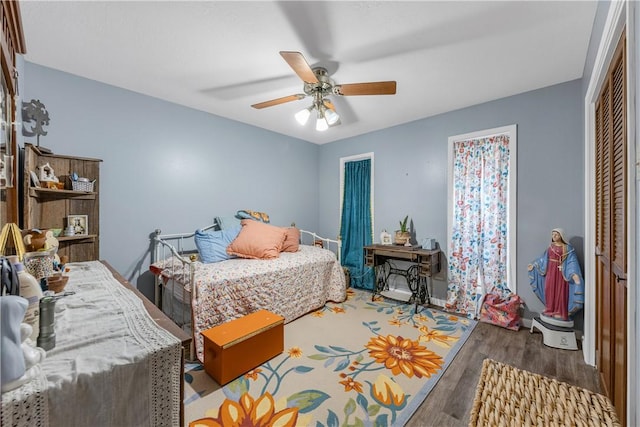 bedroom with hardwood / wood-style floors, ceiling fan, and a closet