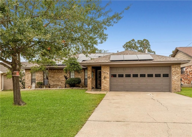 view of front of house with a garage, a front lawn, and solar panels