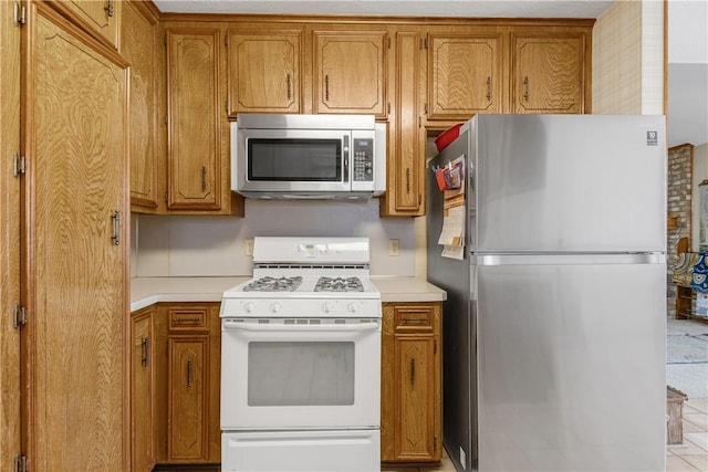 kitchen with stainless steel appliances, light countertops, and brown cabinets