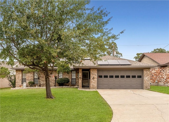 view of front of property featuring solar panels, a front lawn, and a garage