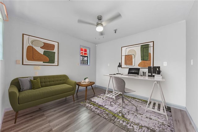 home office featuring wood finished floors, a ceiling fan, and baseboards