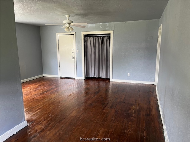 spare room with ceiling fan, dark hardwood / wood-style flooring, and a textured ceiling