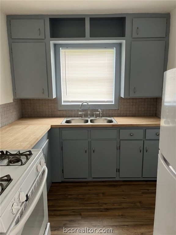 kitchen with white appliances, sink, dark hardwood / wood-style floors, gray cabinets, and tasteful backsplash