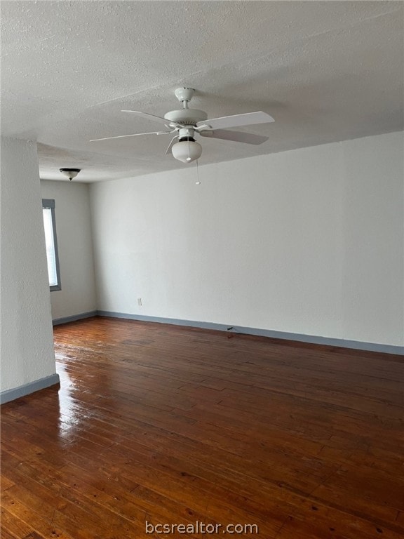 spare room featuring a textured ceiling, ceiling fan, and dark hardwood / wood-style floors