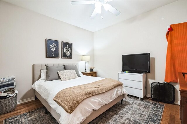 bedroom with baseboards, wood finished floors, and a ceiling fan