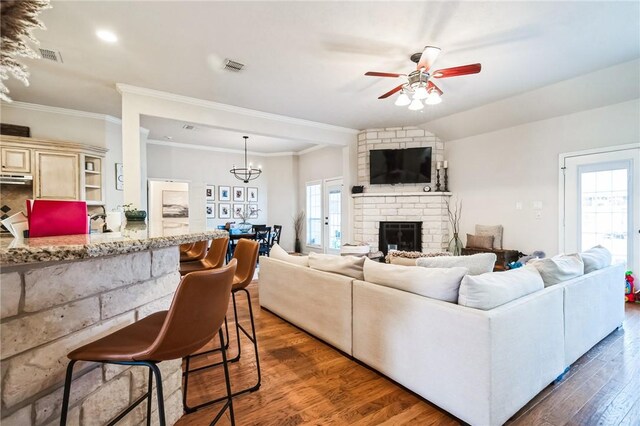 living area with dark wood finished floors, a fireplace, visible vents, and a healthy amount of sunlight