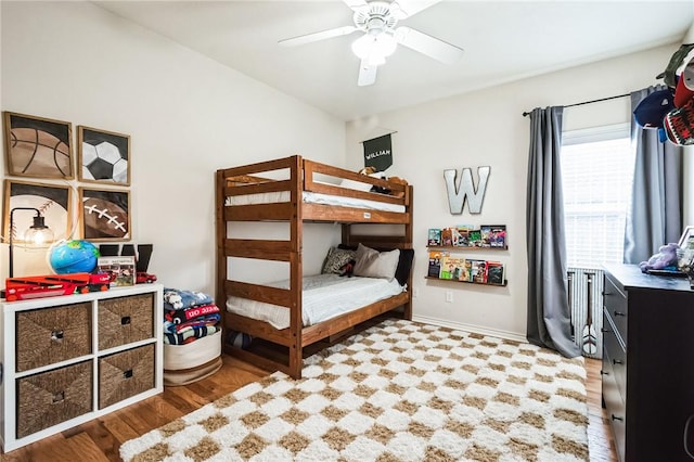 bedroom featuring wood finished floors, baseboards, and ceiling fan