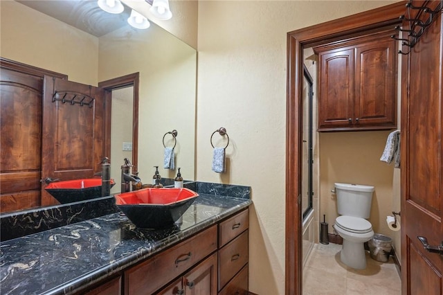 bathroom with toilet, washtub / shower combination, tile patterned flooring, and vanity