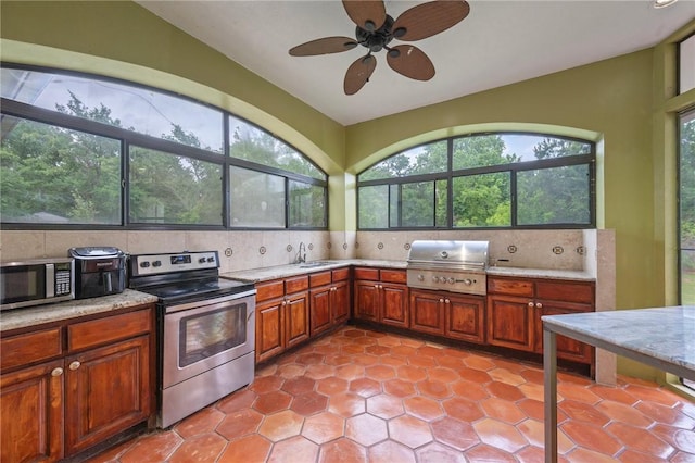 kitchen with lofted ceiling, a wealth of natural light, decorative backsplash, and appliances with stainless steel finishes