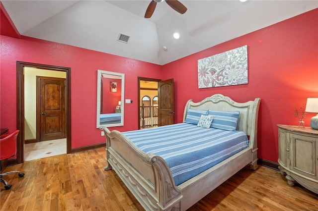 bedroom with vaulted ceiling, a ceiling fan, visible vents, and wood finished floors