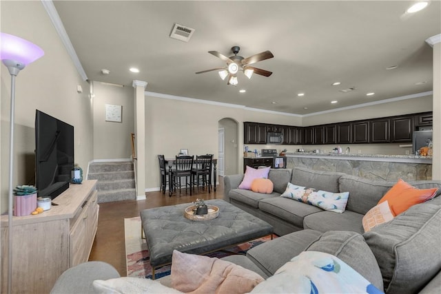 living room featuring ceiling fan, dark hardwood / wood-style flooring, and crown molding