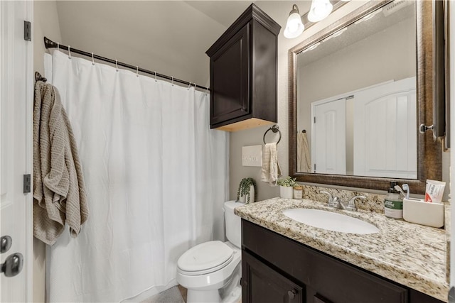 bathroom featuring toilet, vanity, and a shower with curtain