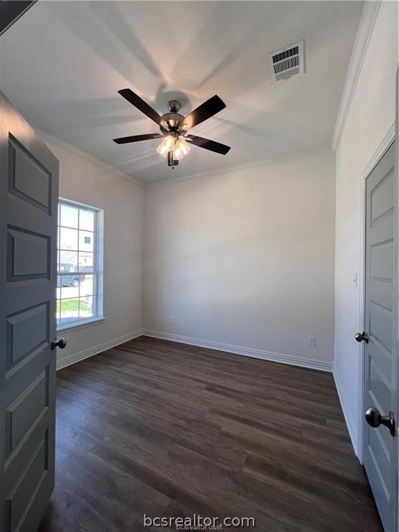 spare room featuring dark hardwood / wood-style floors, ceiling fan, and ornamental molding