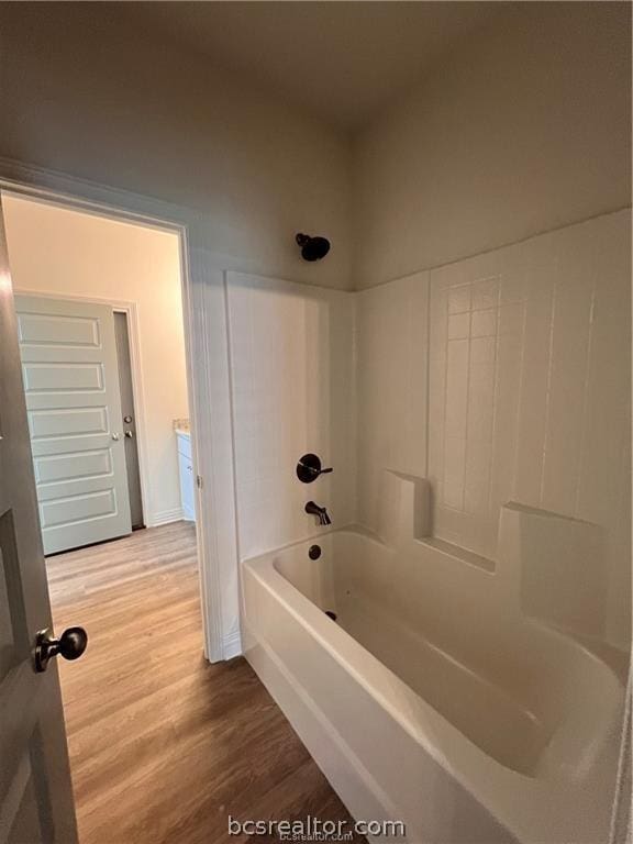 bathroom with hardwood / wood-style flooring and  shower combination