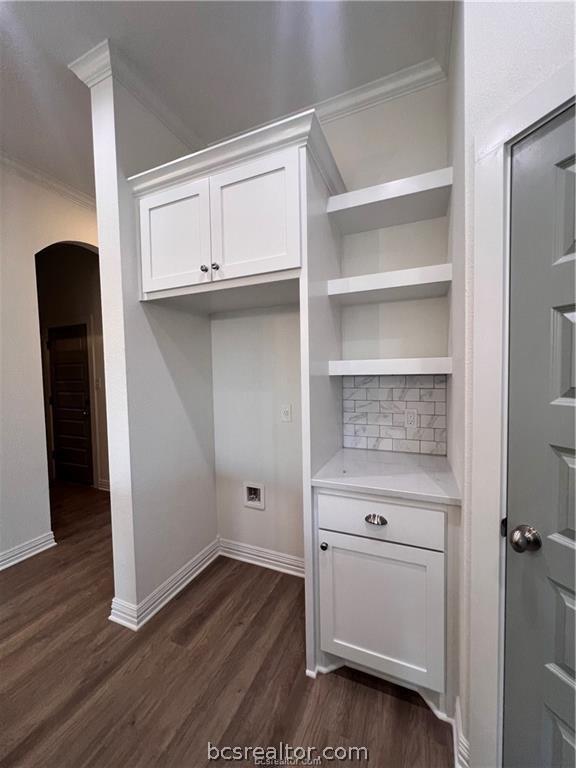 interior space with ornamental molding and dark wood-type flooring