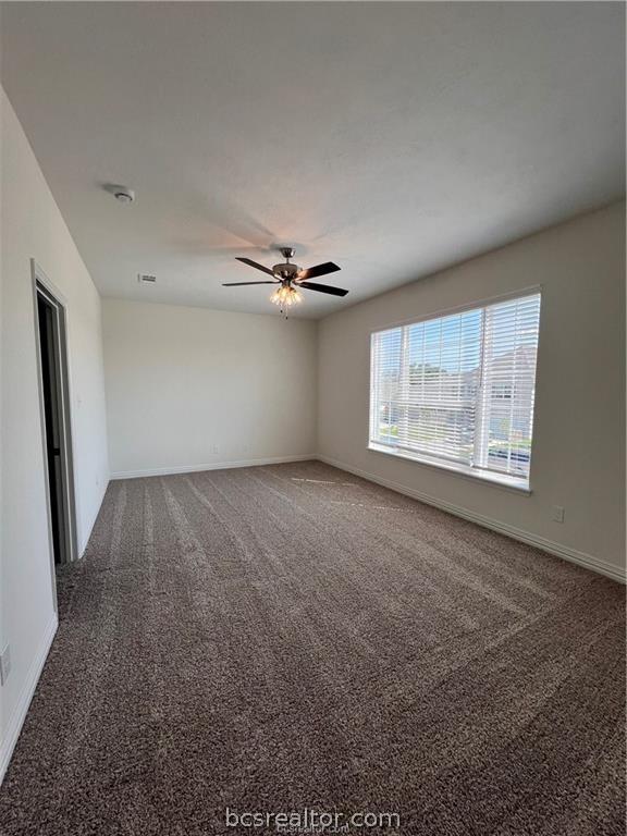 empty room featuring carpet floors and ceiling fan