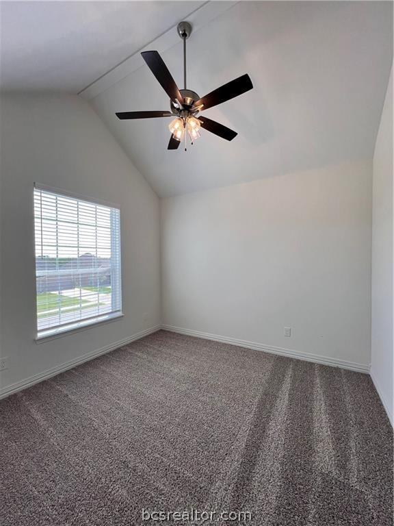 unfurnished room with ceiling fan, carpet, and vaulted ceiling