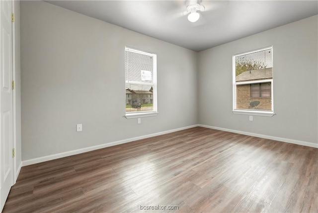 empty room featuring hardwood / wood-style floors, a wealth of natural light, and ceiling fan