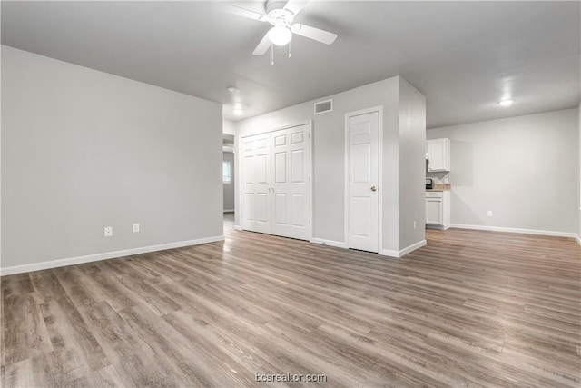 unfurnished bedroom with ceiling fan and light wood-type flooring