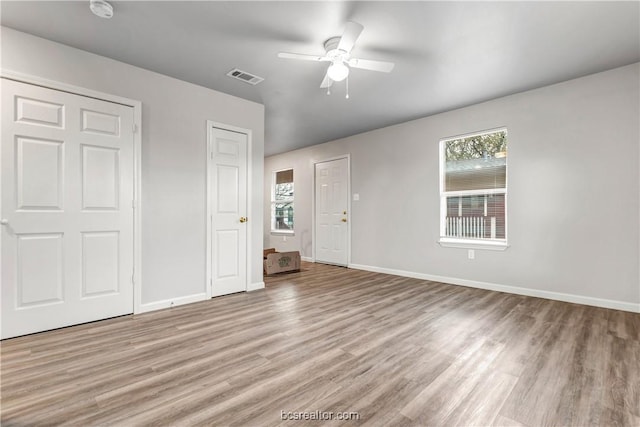 unfurnished bedroom with ceiling fan, multiple windows, and light hardwood / wood-style flooring