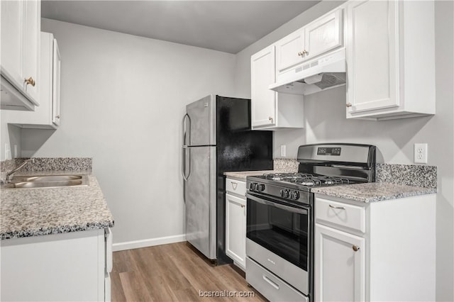 kitchen featuring sink, stainless steel appliances, light hardwood / wood-style floors, light stone countertops, and white cabinets