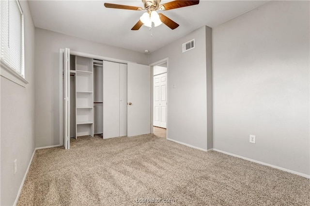 unfurnished bedroom featuring ceiling fan, a closet, and carpet