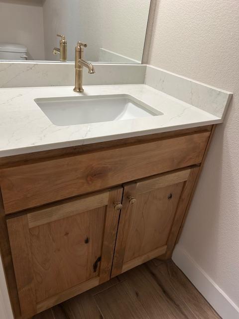 bathroom featuring hardwood / wood-style flooring, vanity, and toilet