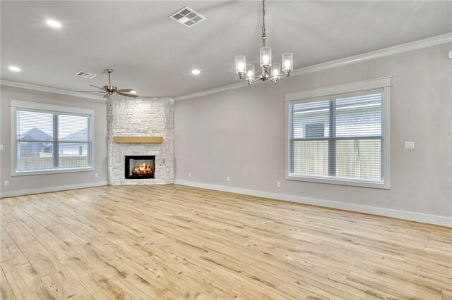 unfurnished living room featuring hardwood / wood-style floors, ceiling fan, a stone fireplace, and ornamental molding