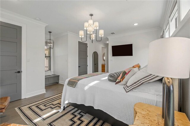 315 Suffolk Ave, College Station, TX 77840 - bedroom with wood finished floors, arched walkways, crown molding, baseboards, and a chandelier