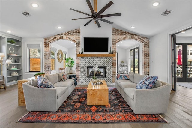315 Suffolk Ave, College Station, TX 77840 - living area featuring wood finished floors, visible vents, lofted ceiling, arched walkways, and a brick fireplace