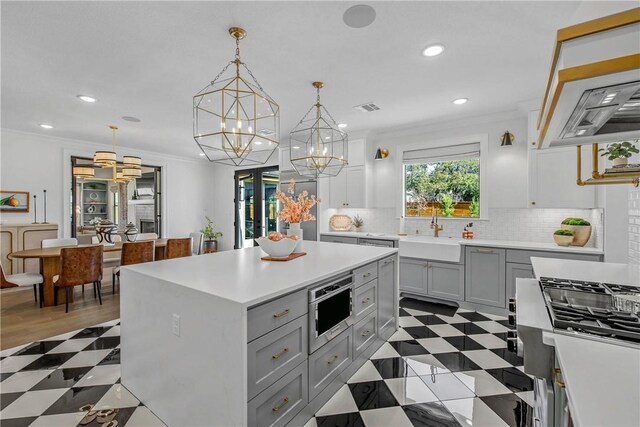 315 Suffolk Ave, College Station, TX 77840 - kitchen featuring tile patterned floors, gray cabinets, a sink, crown molding, and light countertops