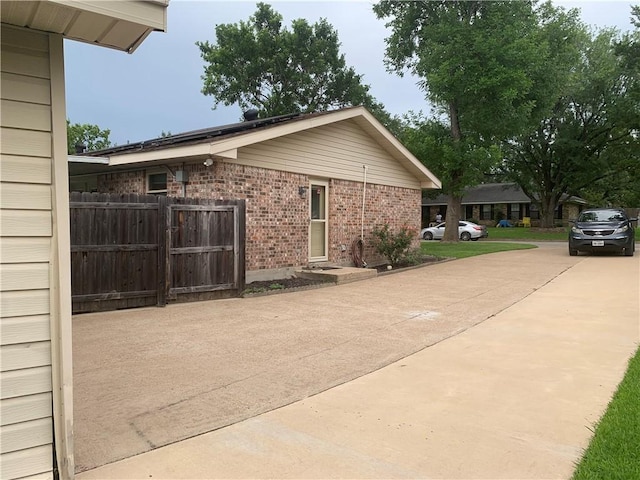 1707 Shawnee St, Navasota, TX 77868 - view of property exterior with brick siding, a gate, and concrete driveway