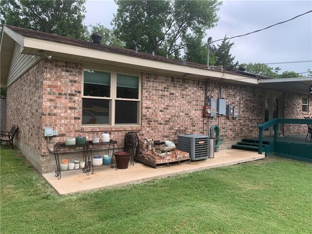 1707 Shawnee St, Navasota, TX 77868 - rear view of house featuring brick siding, a yard, and a patio area