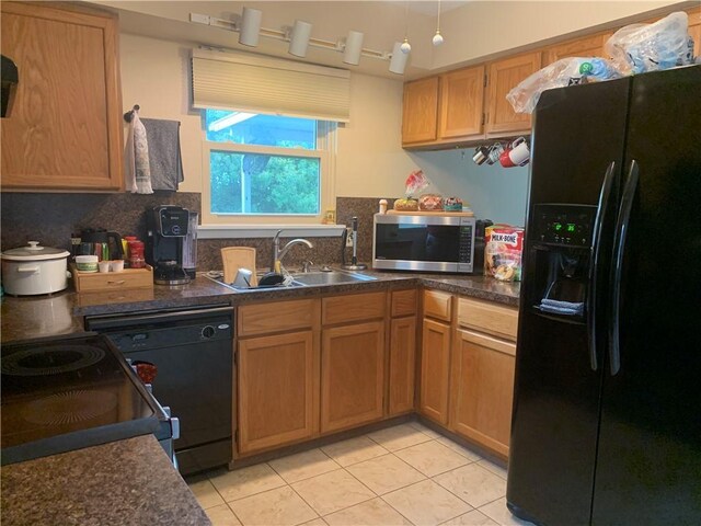 1707 Shawnee St, Navasota, TX 77868 - kitchen featuring black appliances, light tile patterned floors, dark countertops, and decorative backsplash
