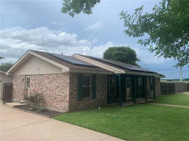 1707 Shawnee St, Navasota, TX 77868 - view of property exterior featuring roof mounted solar panels, brick siding, and covered porch