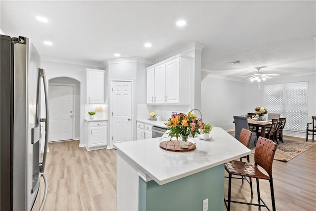 kitchen with stainless steel appliances, a kitchen breakfast bar, kitchen peninsula, and white cabinets