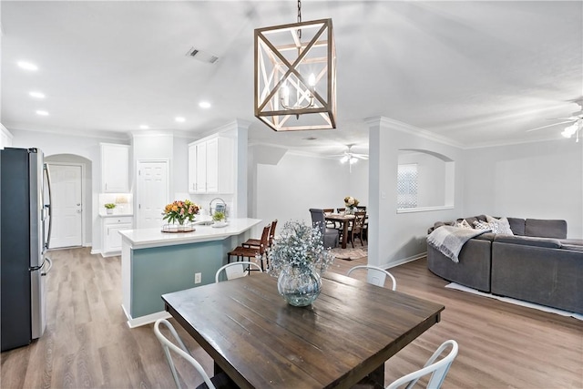 dining area featuring crown molding, ceiling fan, and light hardwood / wood-style flooring