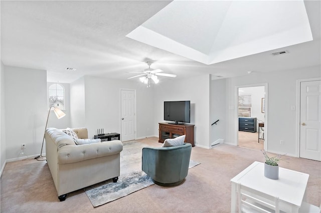 living room with light colored carpet, ceiling fan, and a tray ceiling