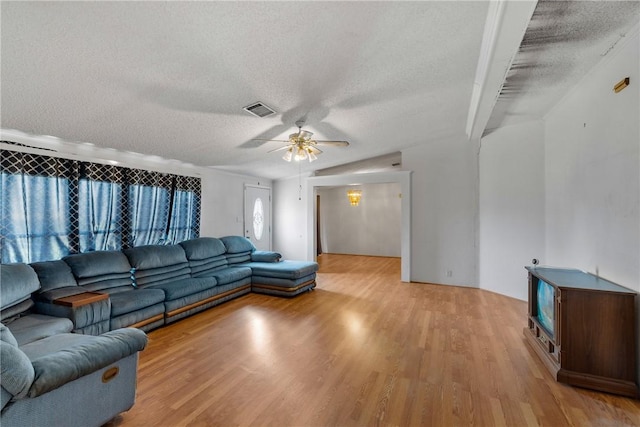 living room with ceiling fan, light hardwood / wood-style floors, and a textured ceiling