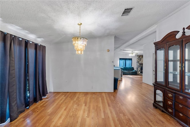 unfurnished room featuring ceiling fan with notable chandelier, light hardwood / wood-style floors, crown molding, and a textured ceiling