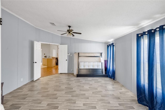 unfurnished bedroom with ceiling fan, light hardwood / wood-style floors, lofted ceiling, and ornamental molding