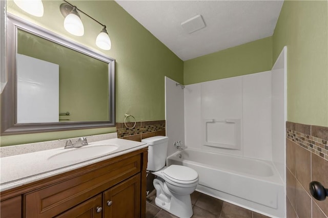 1536 Wolf Run, College Station, TX 77840 - bathroom with tile patterned floors, tile walls, vanity, toilet, and shower / washtub combination