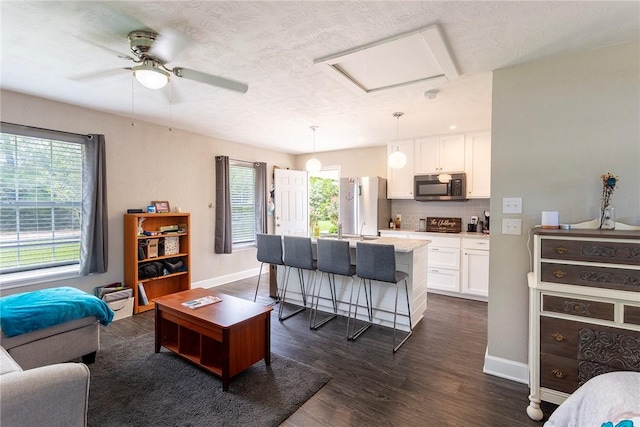 1701 Bradley Rd, College Station, TX 77845 - living area with baseboards, dark wood-style flooring, attic access, and a ceiling fan