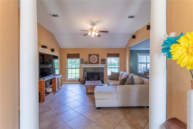 1701 Bradley Rd, College Station, TX 77845 - living room with lofted ceiling, a ceiling fan, a tile fireplace, light tile patterned flooring, and baseboards